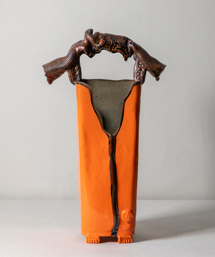 A tall, architectural ceramic vessel featuring a museum grade sculptural handle. Sharp, organic, tailored, and deliberate. 