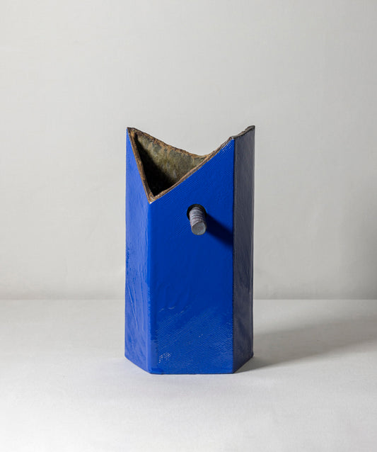 An edgy and truly unique vase made of ceramic drip glaze. The asymmetrical, textured exterior and smooth interior are separated by a removable ceramic pole running through its center.