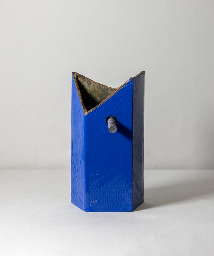 An edgy and truly unique vase made of ceramic drip glaze. The asymmetrical, textured exterior and smooth interior are separated by a removable ceramic pole running through its center.